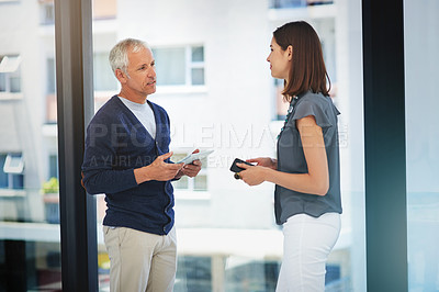 Buy stock photo Cropped shot of two colleagues having a conversation in their office