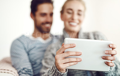 Buy stock photo Couple, hands and tablet for movie, streaming online or news check on couch in living room in house. Blurry, internet subscription and people lounge to relax on digital website and touchscreen app