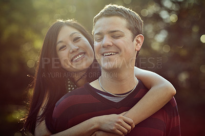 Buy stock photo Shot of an affectionate young couple enjoying a piggyback ride outdoors