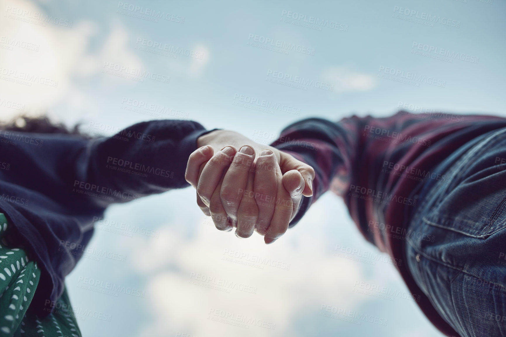 Buy stock photo Low angle shot of an affectionate couple holding hands outdoors