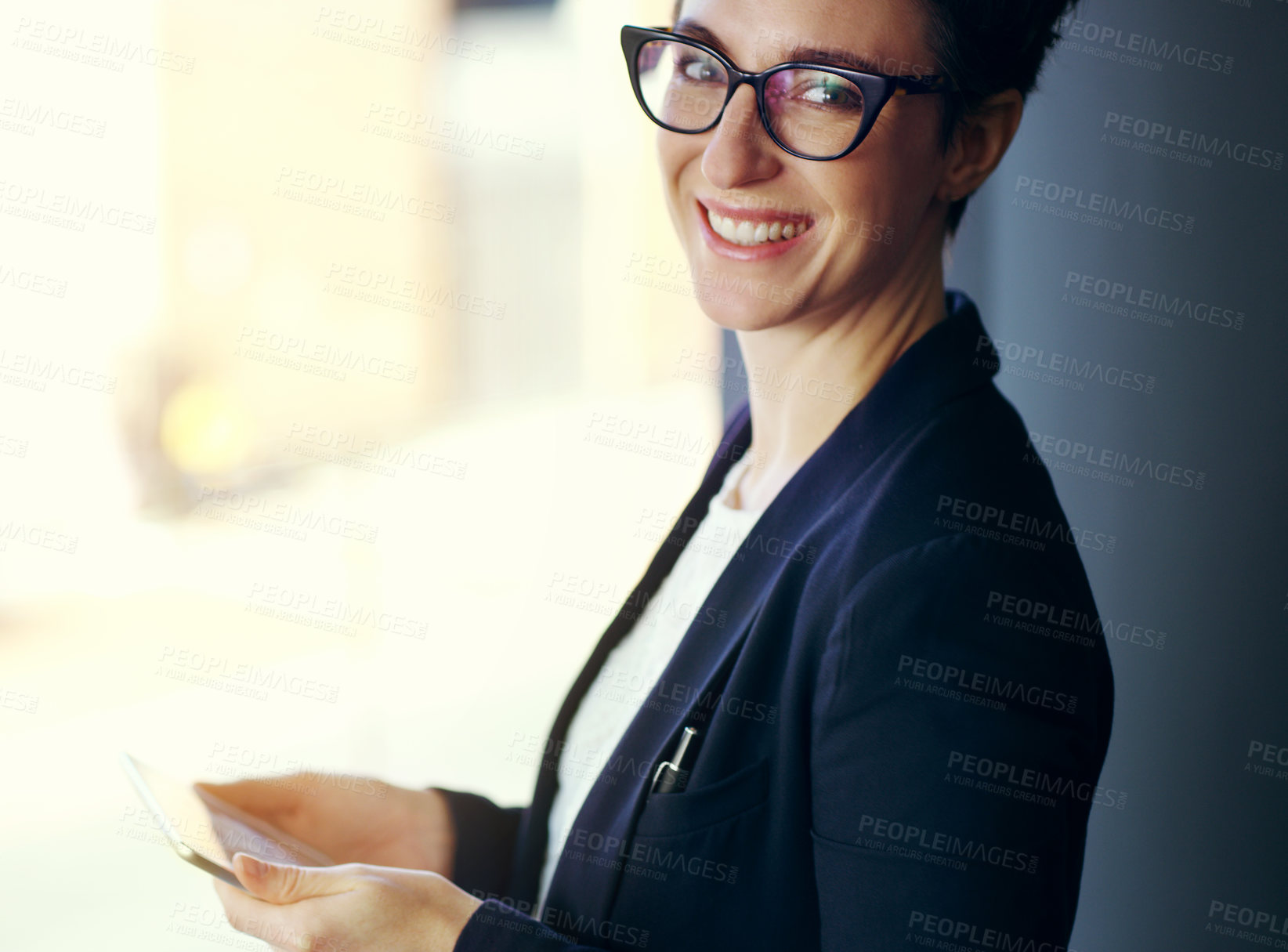 Buy stock photo Cropped portrait of an attractive young businesswoman working on a digital tablet while standing on her office balcony