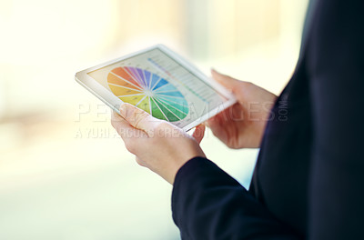 Buy stock photo Cropped shot of an unrecognizable young businesswoman working on a digital tablet while standing on her office balcony