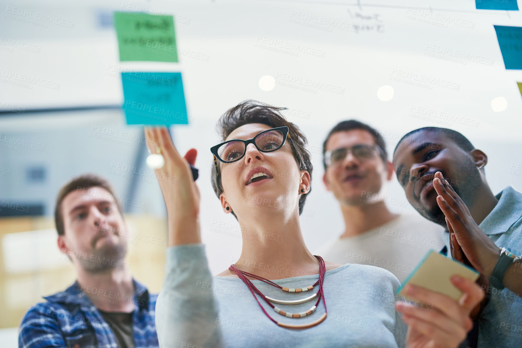 Buy stock photo Talking, woman and ideas on glass for timeline, teaching and brainstorming in workshop. Female leader, presentation and group training in boardroom with sticky note, collaboration and instruction