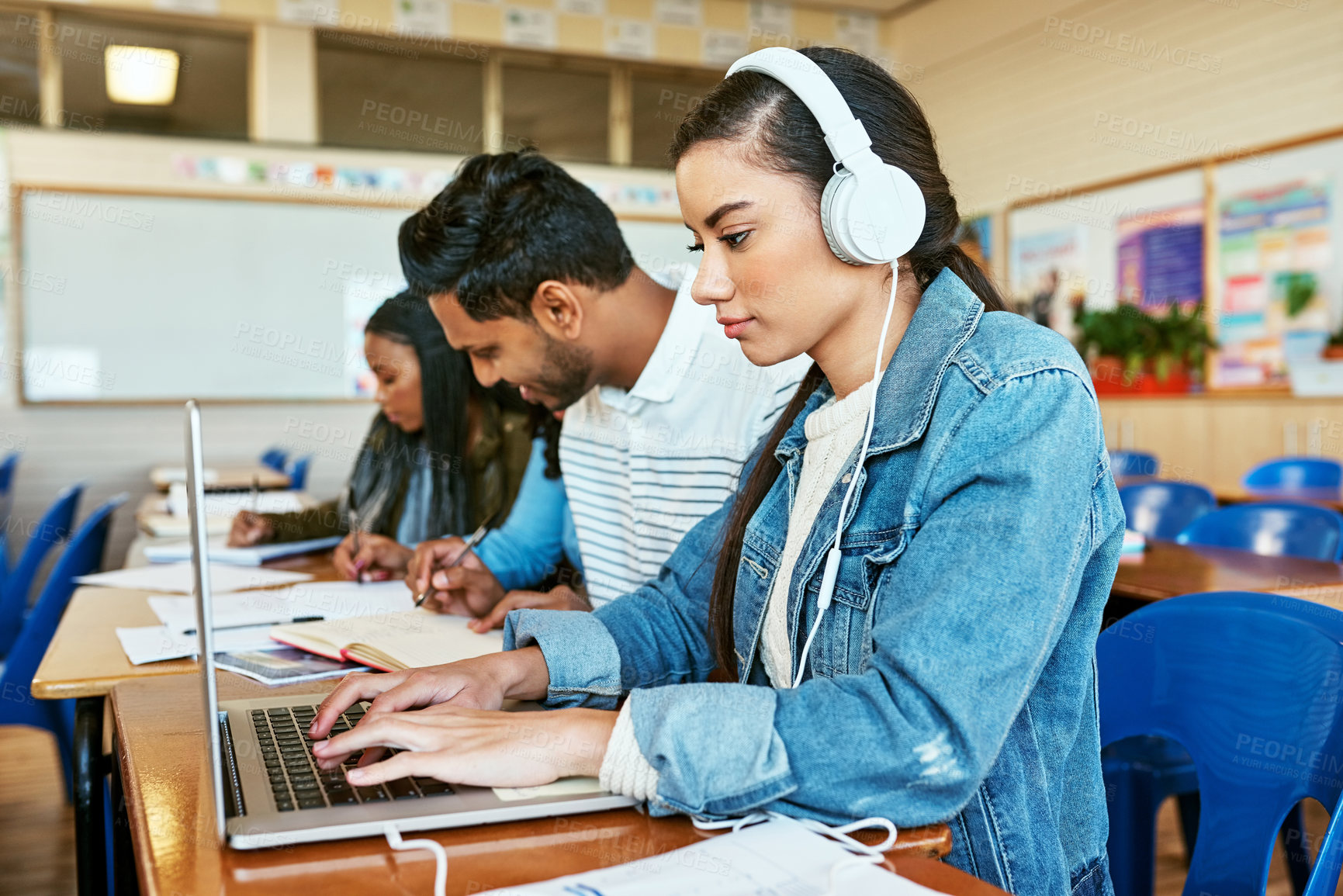 Buy stock photo Cropped shot of an attractive young university student working on her laptop while sitting in class