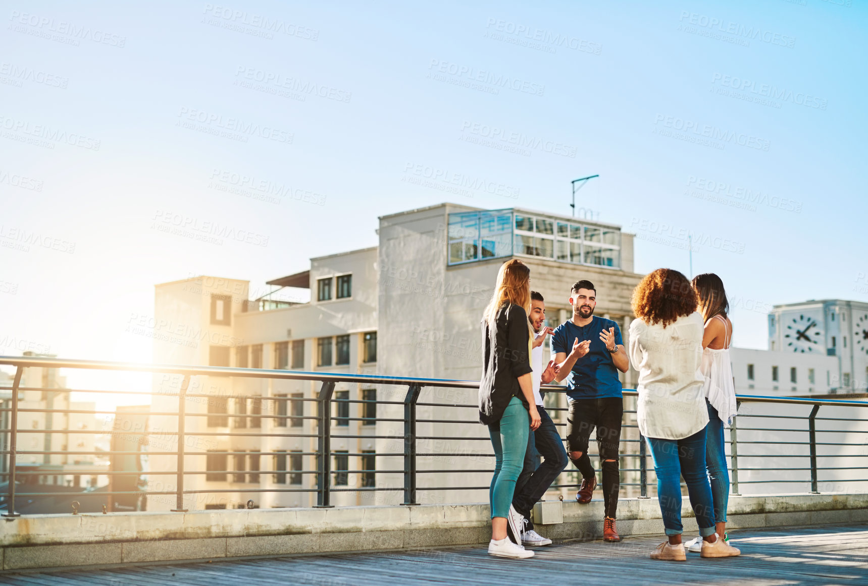 Buy stock photo Shot of young friends spending the day on a rooftop outside