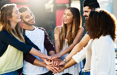 Buy stock photo Cropped shot of a group of young people putting their hands together in unity outside