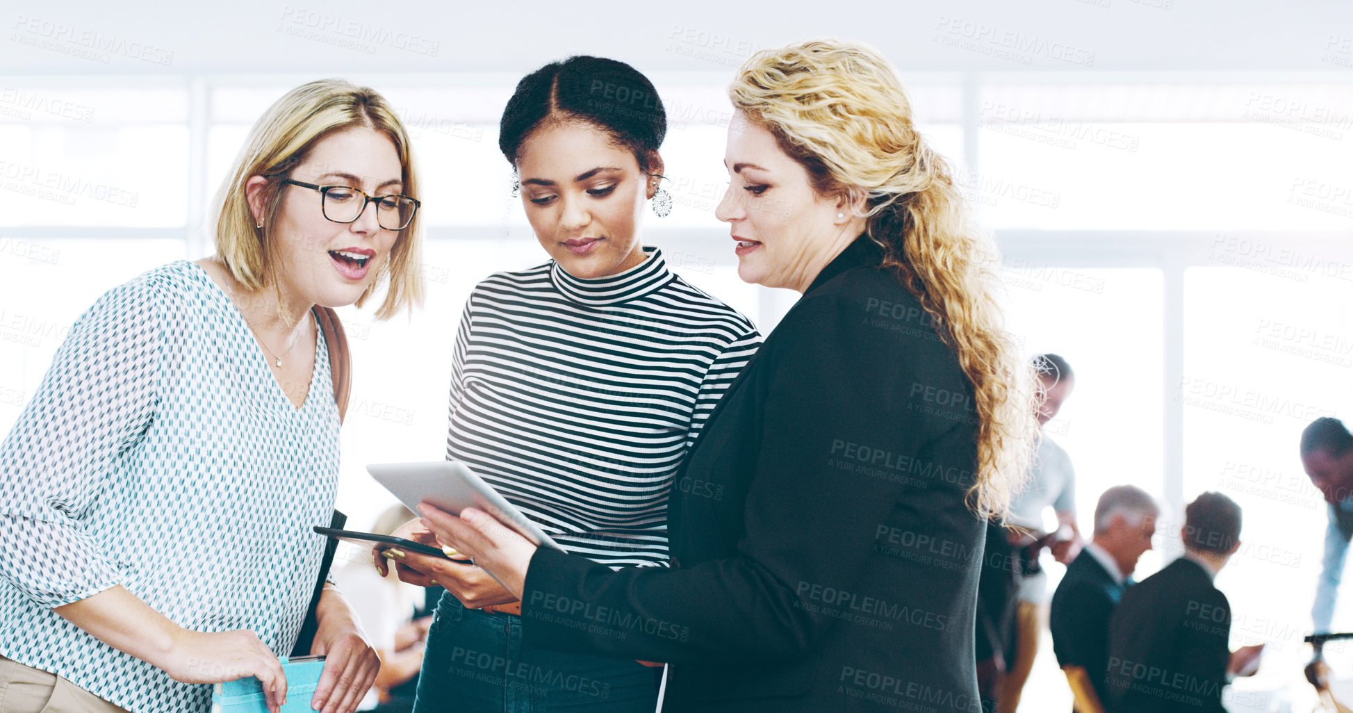 Buy stock photo Cropped shot of three corporate businesswomen standing in a huddle with digital tablets in hand