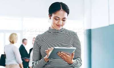 Buy stock photo Cropped shot of an attractive young businesswoman using a tablet in the office with her colleagues in the background