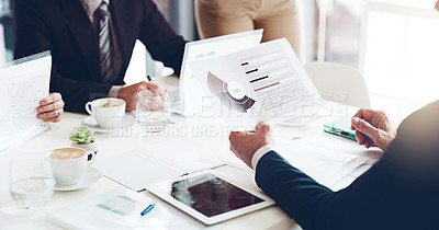 Buy stock photo High angle shot of a group of unrecognizable businesspeople looking at paperwork in the boardroom