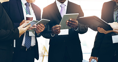 Buy stock photo Cropped shot of a group of unrecognizable businesspeople standing in a huddle with digital tablets in hand