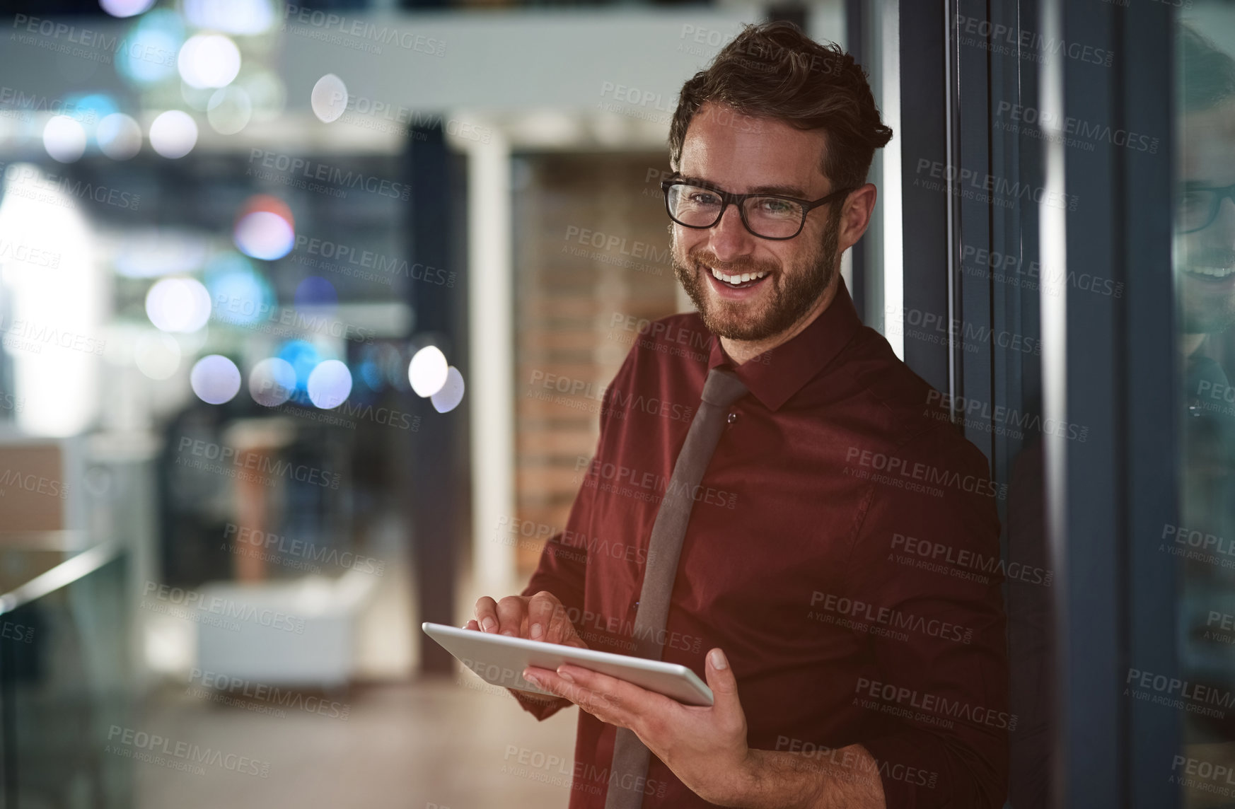 Buy stock photo Shot of a young businessman using a digital tablet in a modern office