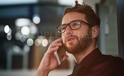 Buy stock photo Shot of a young businessman using a mobile phone in a modern office