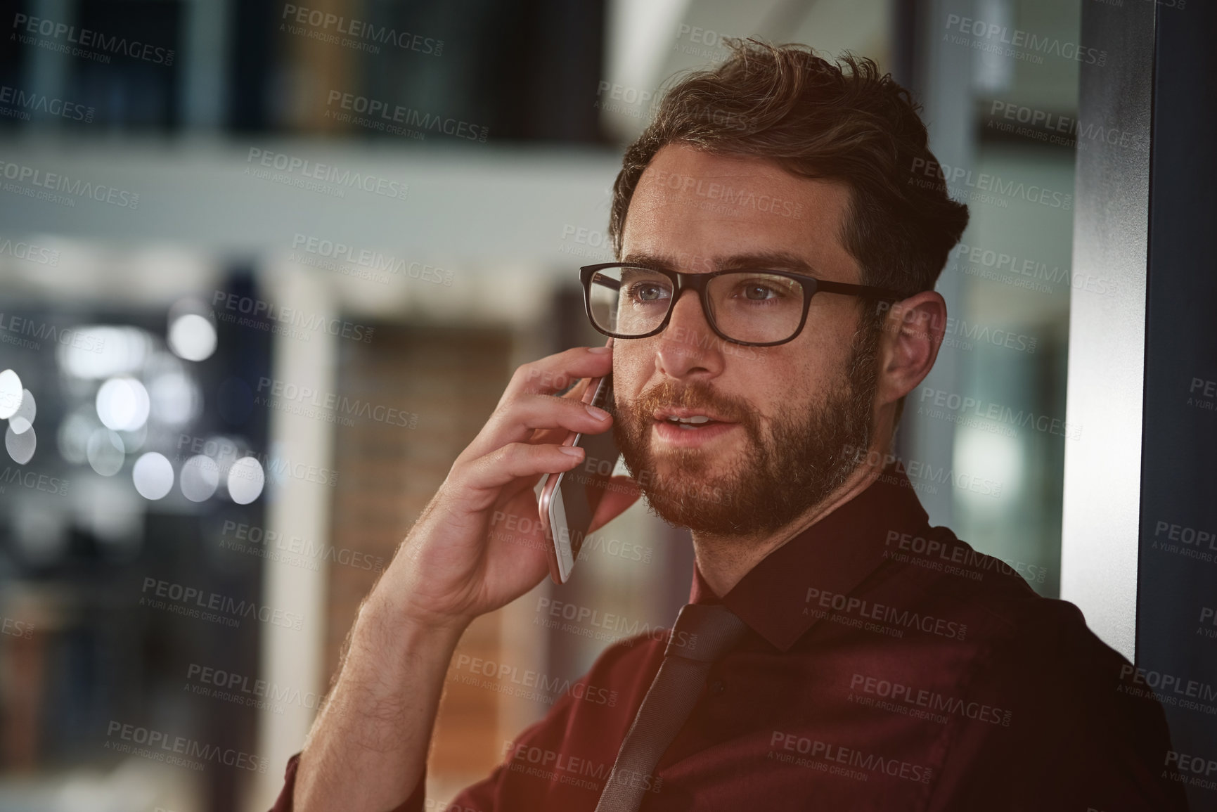 Buy stock photo Shot of a young businessman using a mobile phone in a modern office