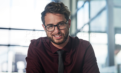 Buy stock photo Portrait of a confident young businessman sitting in a modern office