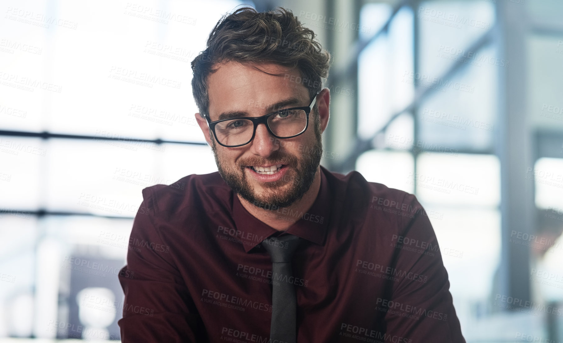 Buy stock photo Portrait of a confident young businessman sitting in a modern office