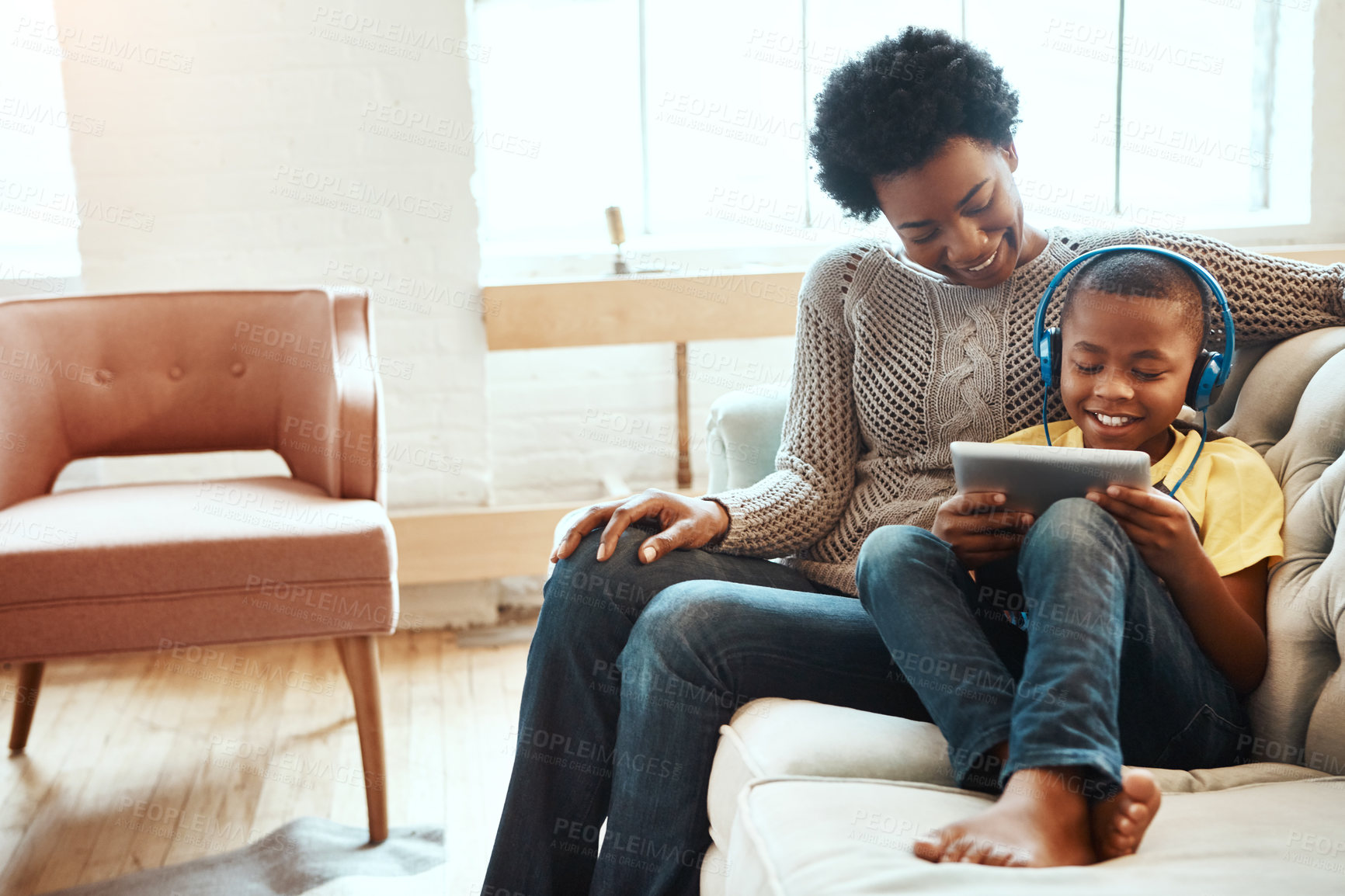 Buy stock photo Tablet, mother and boy with headphones on sofa for digital media, streaming service and bonding. Happy, black family and kid with tech at home for online movie, connectivity and network subscription