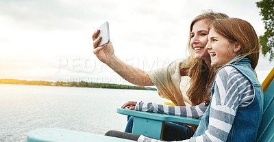 Buy stock photo Shot of a mother and her daughter taking a selfie together outdoors