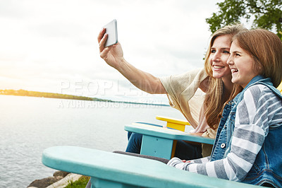 Buy stock photo Shot of a mother and her daughter taking a selfie together outdoors