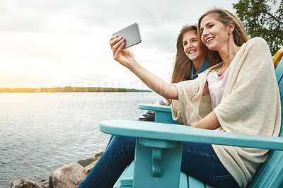 Buy stock photo Shot of a mother and her daughter taking a selfie together outdoors