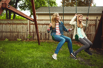 Buy stock photo Shot of a mother and her daughter playing on a swing in their backyard