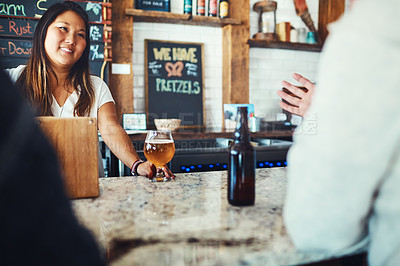 Buy stock photo Shot of a young woman serving drinks in a bar 