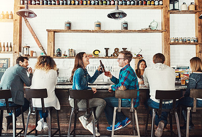 Buy stock photo Shot of a young couple enjoying a drink at a bar