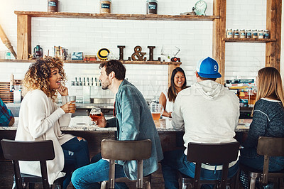 Buy stock photo Shot of a young couple enjoying a drink at a bar