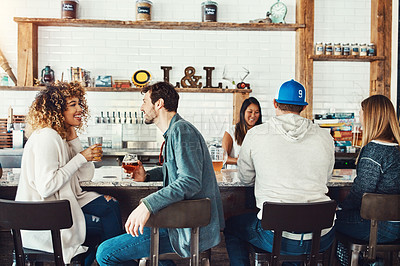 Buy stock photo Shot of young people enjoying a drink at a bar