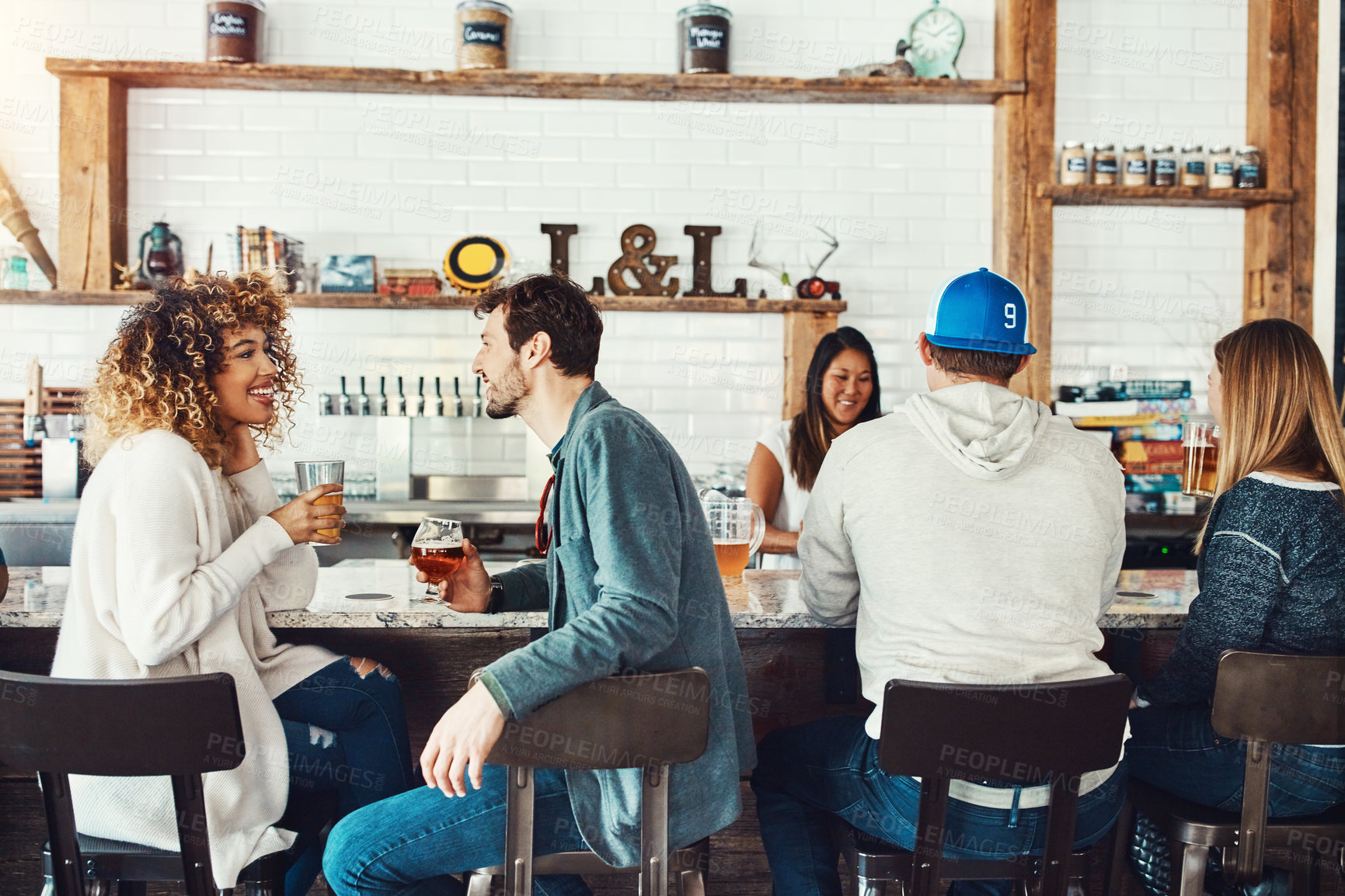 Buy stock photo Shot of young people enjoying a drink at a bar