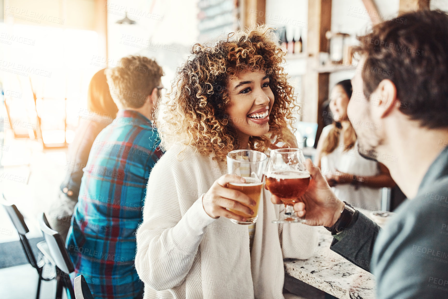 Buy stock photo Shot of a young couple enjoying a drink at a bar