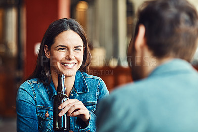 Buy stock photo Shot of a happy young woman enjoying the company in a bar