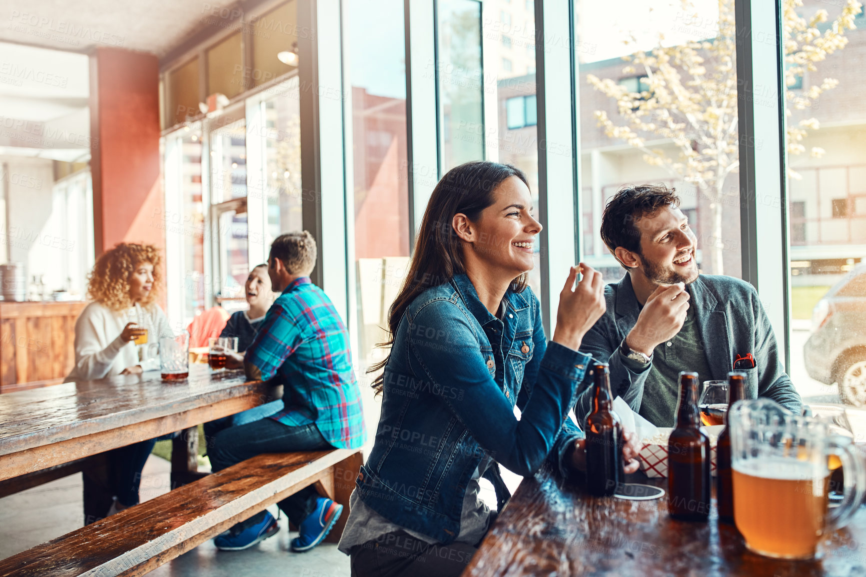 Buy stock photo Date, talking and couple in restaurant, love and bonding together with beer. Hospitality, man and woman in bar, conversation and laughing with humor, happiness and relationship with weekend break