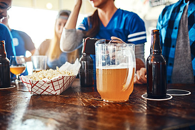Buy stock photo Cropped shot of a jug of beer and popcorn on a counter at a sports bar
