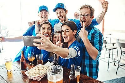 Buy stock photo Shot of a group of friends taking a selfie while watching a sports game at a bar