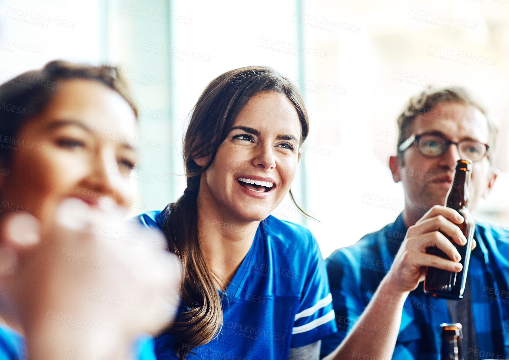 Buy stock photo A group of excited friends cheering on their favourite team at the bar