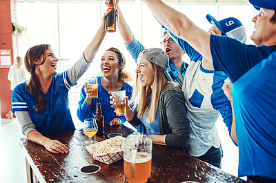 Buy stock photo Shot of a group of friends watching their favorite team live in a sports bar