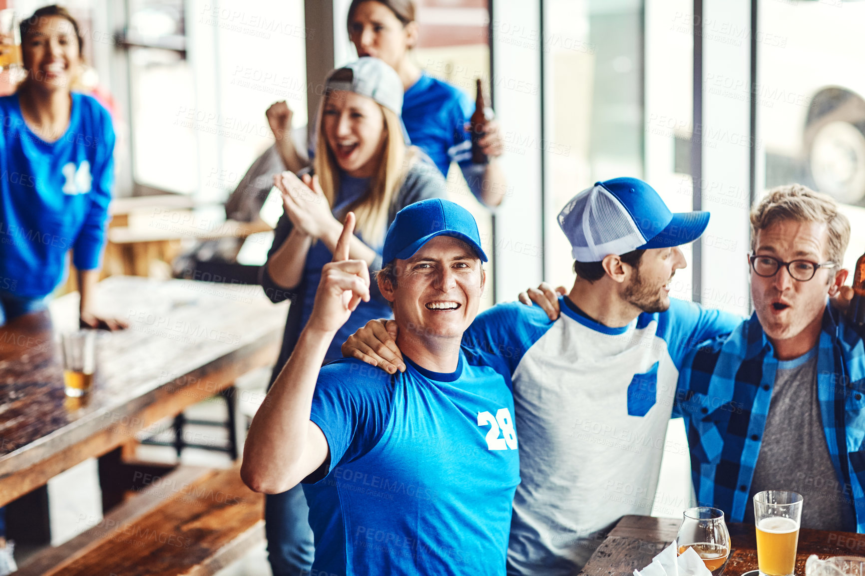 Buy stock photo Watching tv, excited and friends with beer, bar and cheering for win and social gathering for match. Happy, people and fans with alcohol for celebration, entertainment or streaming sport team success