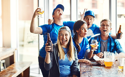 Buy stock photo Shot of a group of friends cheering while watching a sports game at a bar