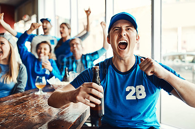 Buy stock photo Shot of a man cheering while watching a sports game with friends at a bar