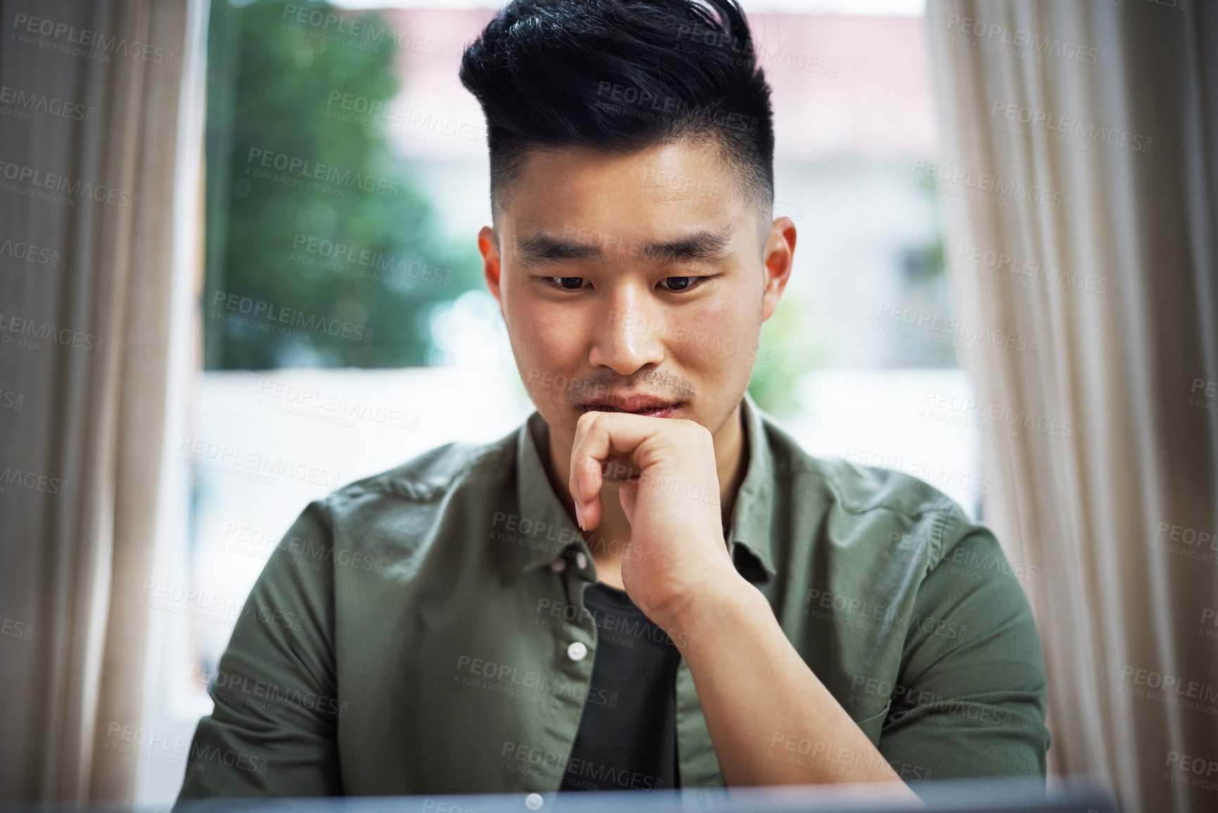 Buy stock photo Cropped shot of a handsome young man working on his laptop at home