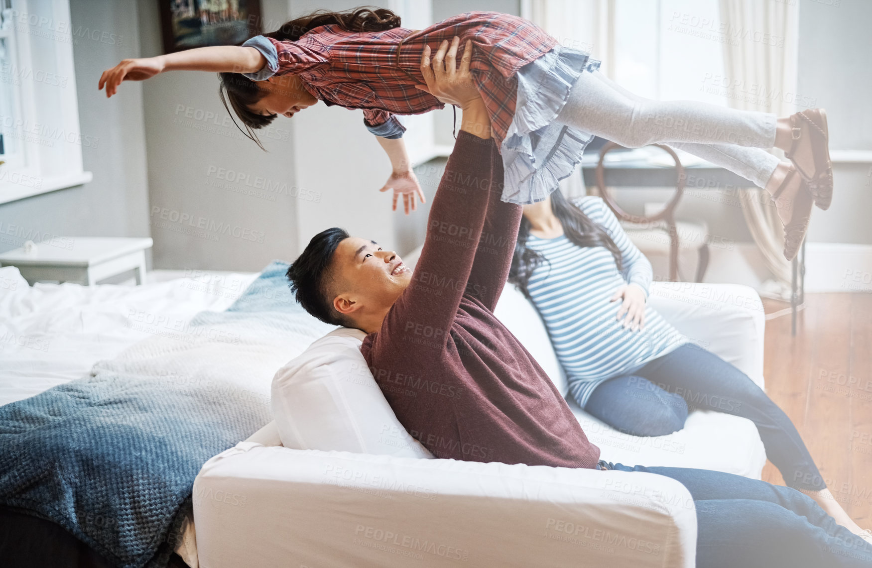 Buy stock photo Cropped shot of a handsome young man playing with his daughter on the sofa at home