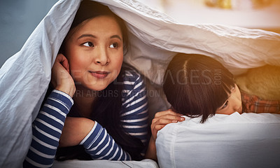 Buy stock photo Cropped shot of an attractive young woman and her daughter lying in a bed under the covers