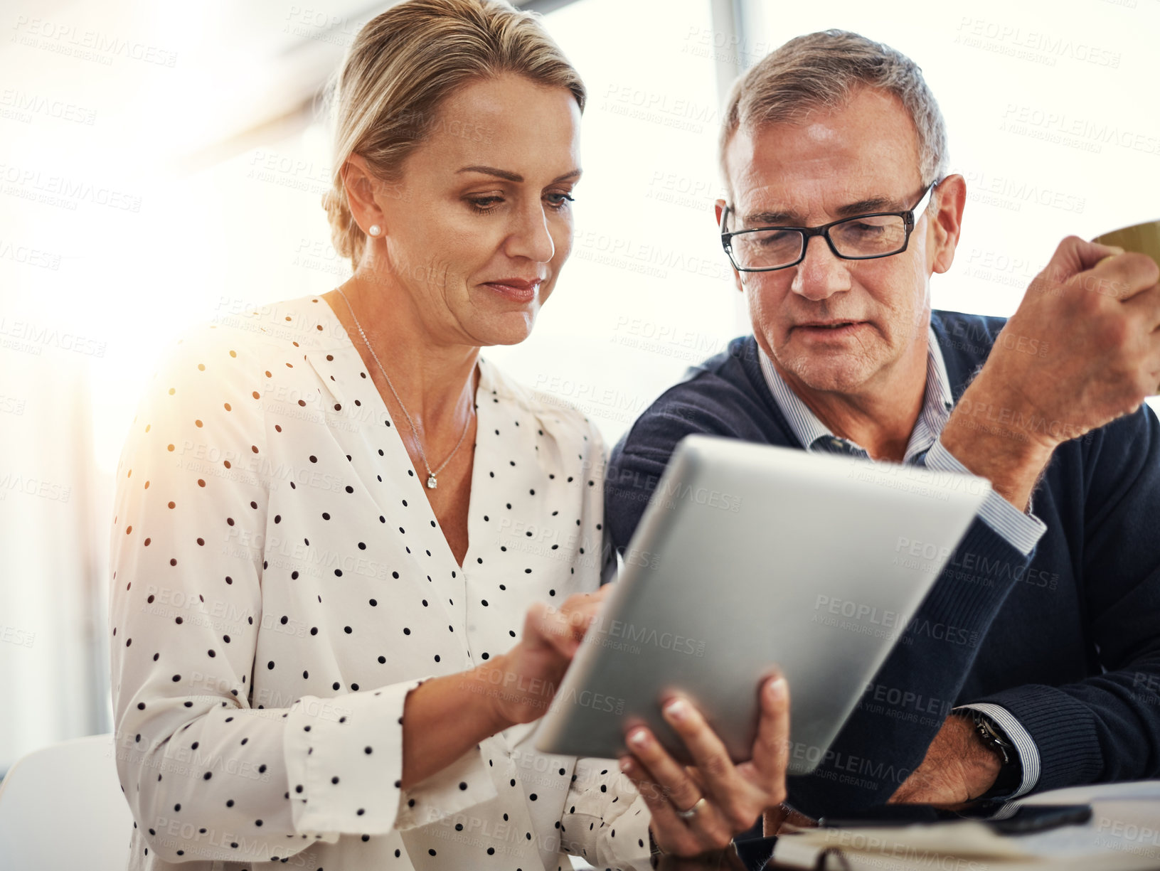 Buy stock photo Shot of a mature couple using a digital tablet together at home