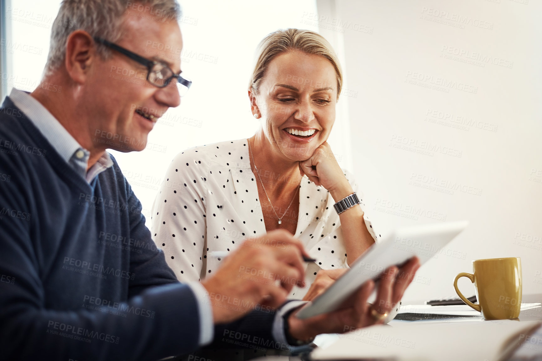 Buy stock photo Shot of a mature couple using a digital tablet together at home