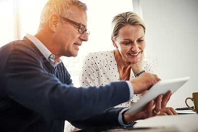 Buy stock photo Shot of a mature couple using a digital tablet together at home