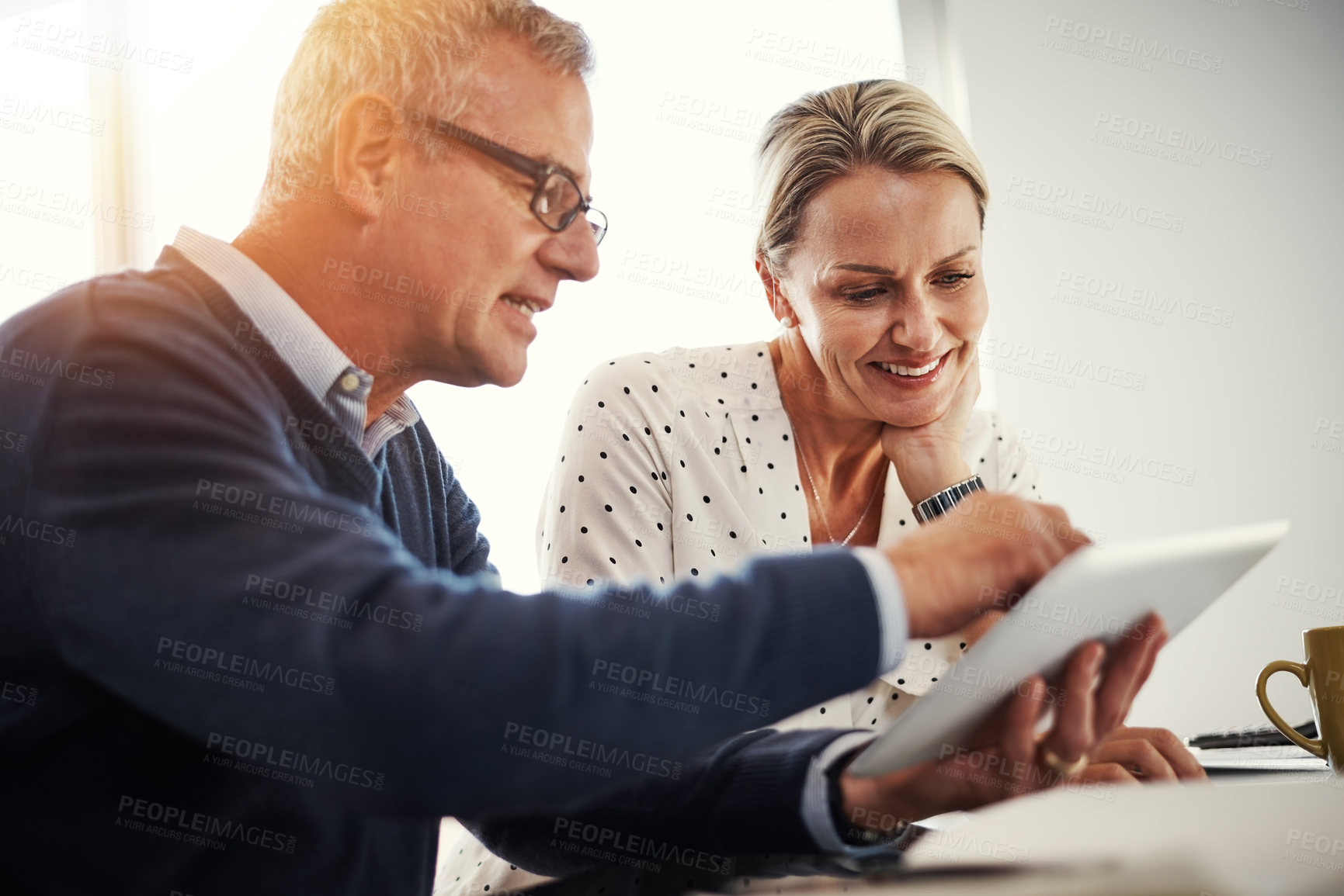 Buy stock photo Shot of a mature couple using a digital tablet together at home