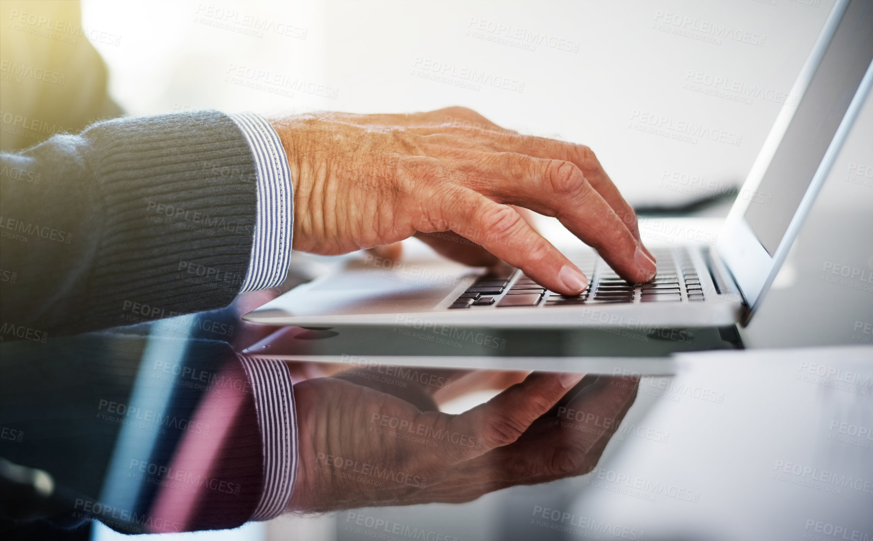 Buy stock photo Cropped shot of a businessman using a laptop at his work desk