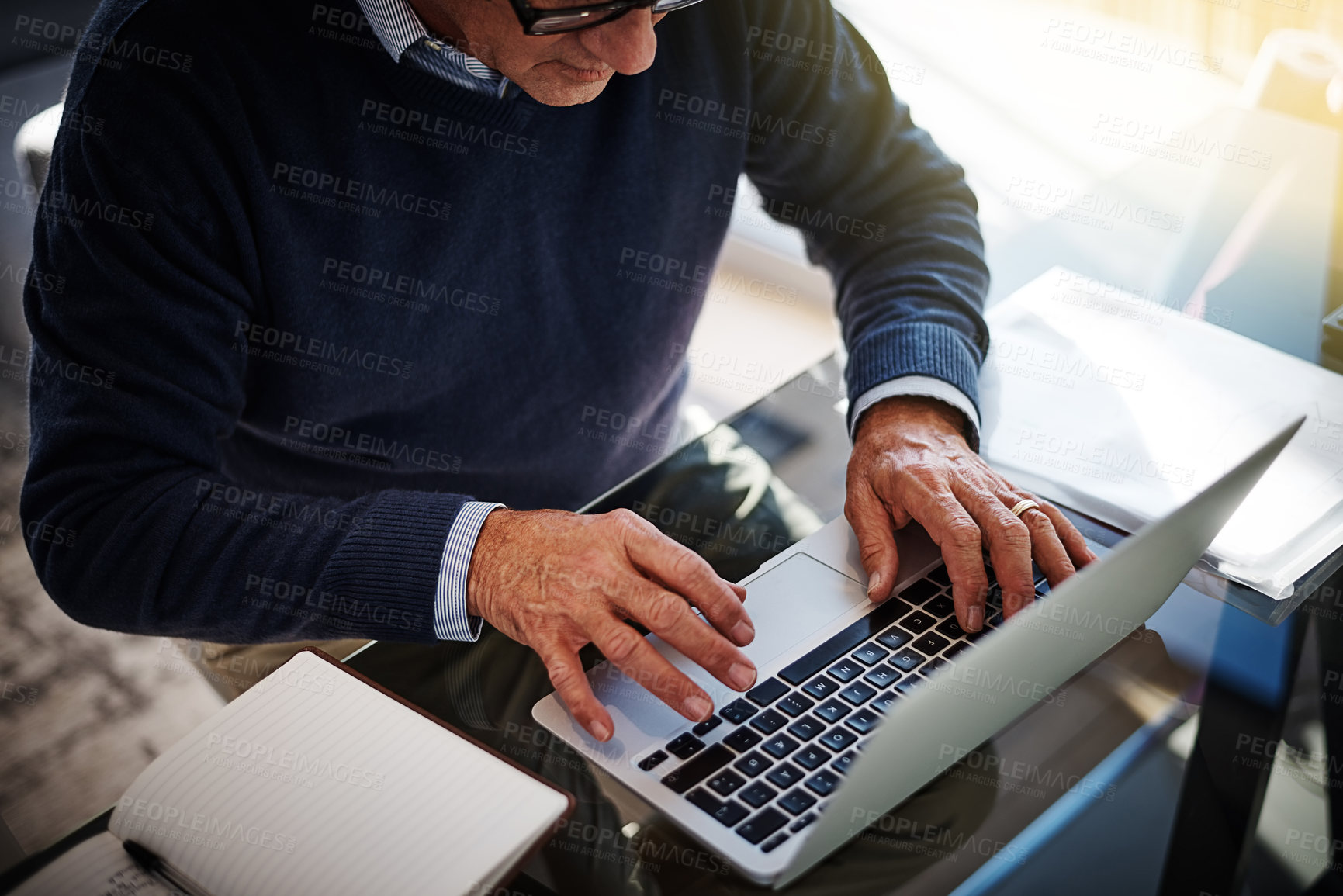 Buy stock photo Cropped shot of a businessman using a laptop at his work desk