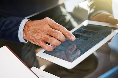 Buy stock photo Cropped shot of a businessman using a digital tablet at his work desk