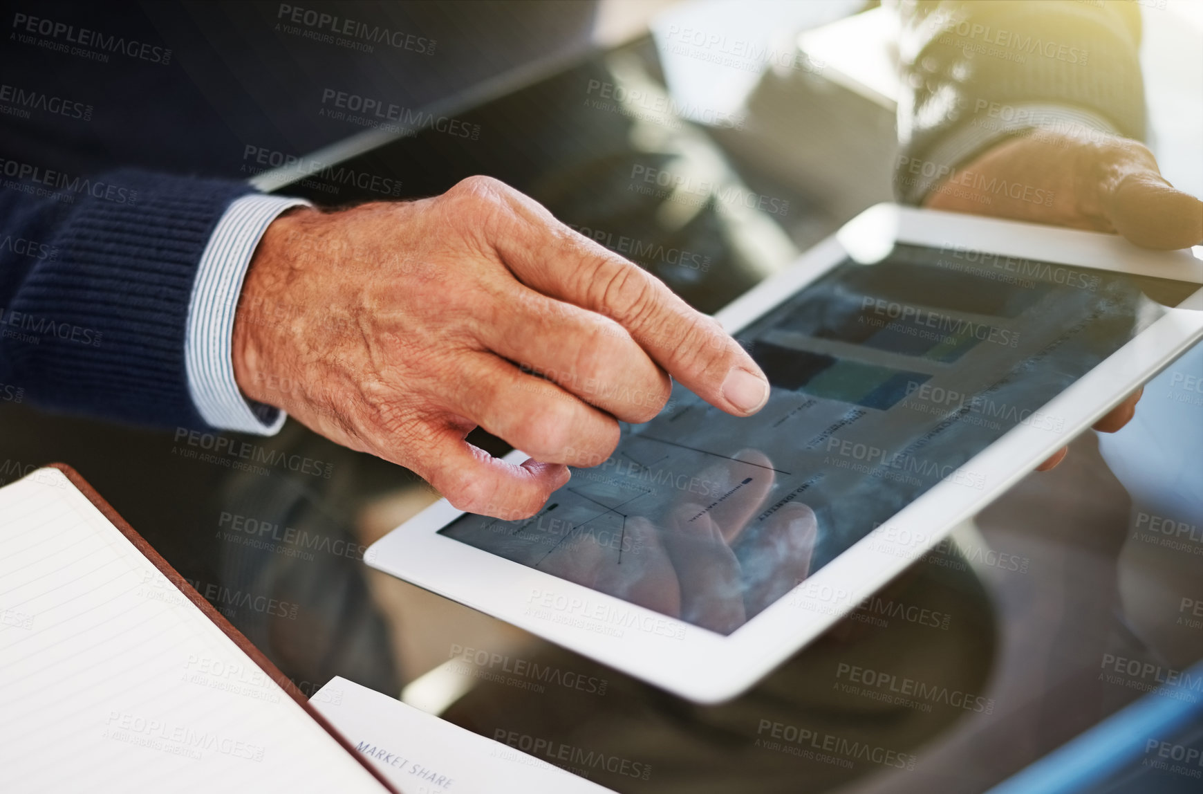 Buy stock photo Cropped shot of a businessman using a digital tablet at his work desk